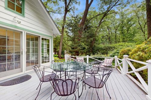 a patio with a glass table and chairs on a deck at Chalet May in Michiana