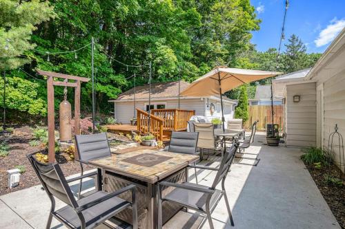 a patio with a table and chairs and an umbrella at Serenity Now in Saugatuck