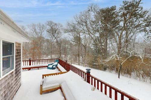 a porch covered in snow next to a house at Fresh Pond Chateau in Oak Bluffs