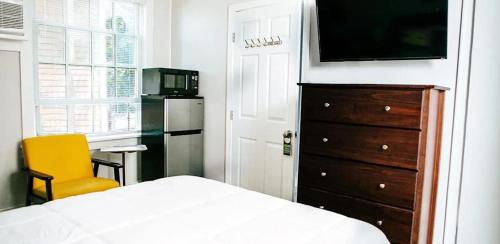 a bedroom with a bed and a dresser with a television at Paul Revere in Provincetown