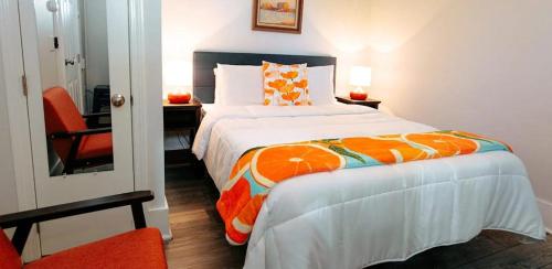 a bedroom with a large bed with an orange blanket at Myles Standish in Provincetown
