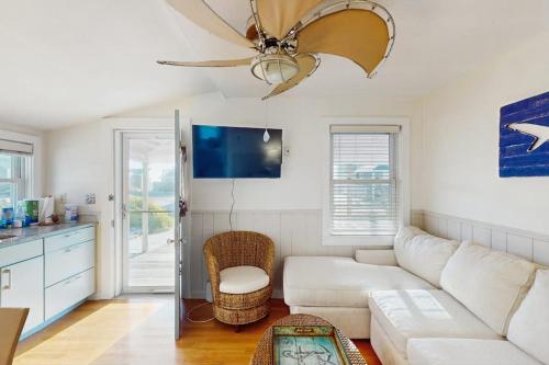 a living room with a white couch and a ceiling fan at Bayside Breeze in Truro