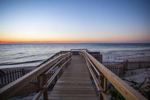 a wooden boardwalk leading to the beach at sunset at Fairway Bliss at Ocean Edge in Brewster