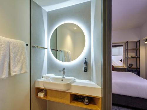 a bathroom with a sink and a mirror at ibis Hamilton Tainui in Hamilton