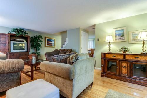 a living room with a couch and a tv at Island Sanctuary in Oak Bluffs