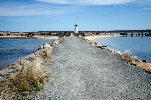 a road leading to a lighthouse on a beach at Harbor Cove Cottage in Edgartown