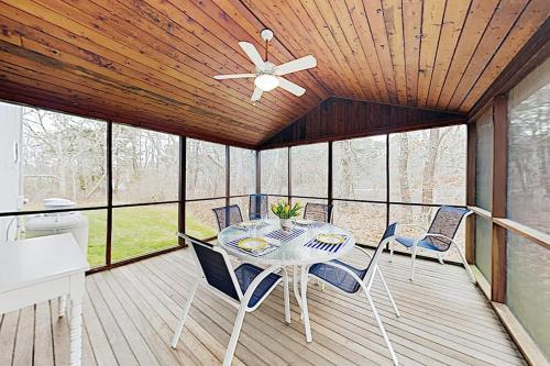 a dining room with a table and chairs on a deck at Harbor Cove Cottage in Edgartown