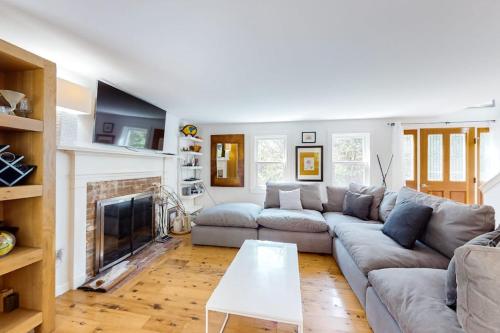 a living room with a couch and a fireplace at Osprey View Villa in Dennis
