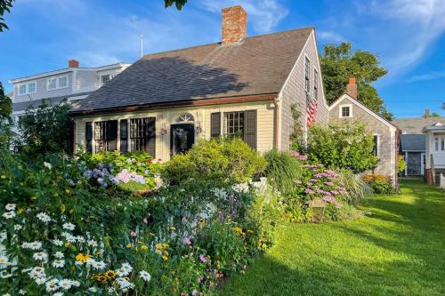 a house with a garden of flowers in the yard at The Groggy Anchor in Provincetown