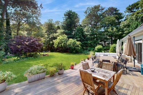 a backyard with a wooden deck with a table and chairs at Bumps River Bungalow in Centerville