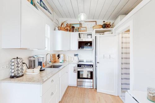 a kitchen with white cabinets and a white refrigerator at Long Point Getaway in Provincetown
