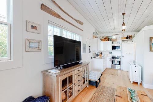 a kitchen with a large television on a wooden cabinet at Long Point Getaway in Provincetown