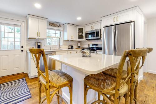 a kitchen with a white counter and two chairs at Harbortown Hideaway in Falmouth