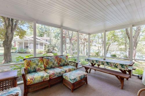 a screened in porch with a couch and a table at Pickerel Cove Cottage in Mashpee