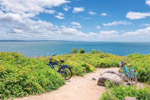 two bikes parked on a dirt path near the ocean at Oyster Beach Bungalow in Chatham