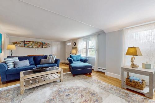 a living room with a blue couch and chairs at Namskaket Retreat in Orleans