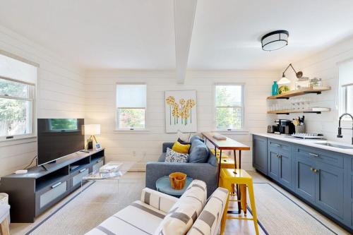 a living room with a blue couch and a kitchen at Long Pier Lodge in Provincetown