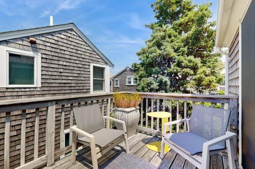 a deck with two chairs and a table on it at Long Pier Lodge in Provincetown