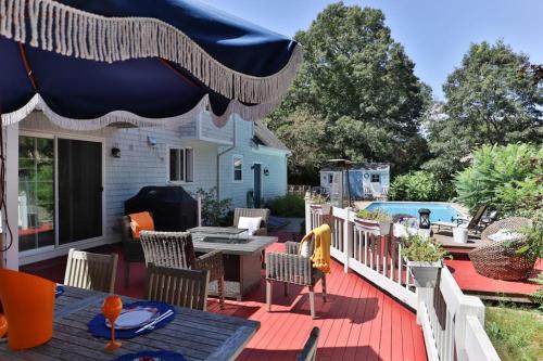 a patio with a table and chairs and an umbrella at Moon Compass Manor in Sandwich