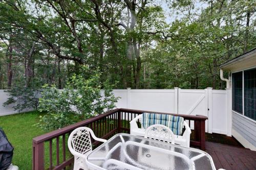 a patio with two chairs and a table on a deck at Lobster Rock Retreat in Barnstable