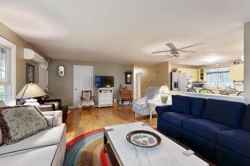a living room with blue couches and a kitchen at Lobster Rock Retreat in Barnstable