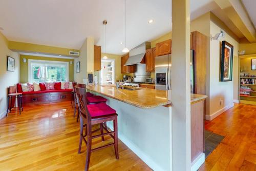a large kitchen with a counter top and a living room at Yellow Brick Road House in Oak Bluffs