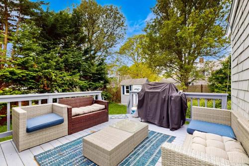 a patio with two couches and chairs on a fence at Cape Beach Bungalow in Dennis Port