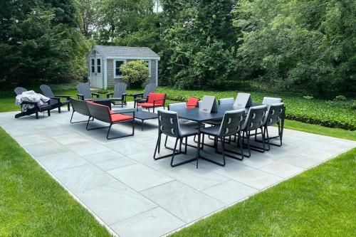 a patio with tables and chairs on a lawn at East Chop 90 in Oak Bluffs