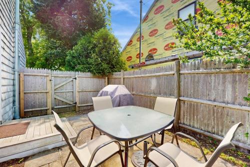 a table and chairs on a patio with a fence at Salty Kisses Unit 20 in Yarmouth