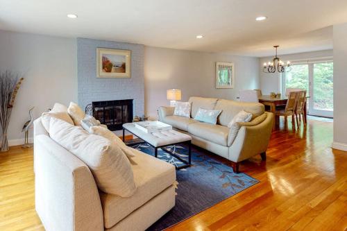 a living room with two couches and a fireplace at Birch Grove in Mashpee