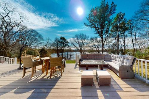 eine Terrasse mit einem Sofa und einem Tisch und Stühlen in der Unterkunft Lovells Landing in Cotuit
