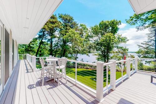a white deck with a table and chairs on it at Follins Estate in Yarmouth Port