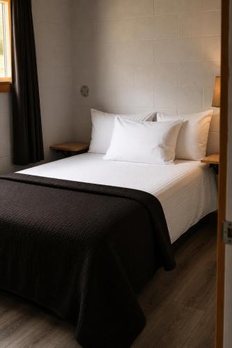 a bedroom with a large bed with white sheets and pillows at Spahats Creek Resort in Clearwater