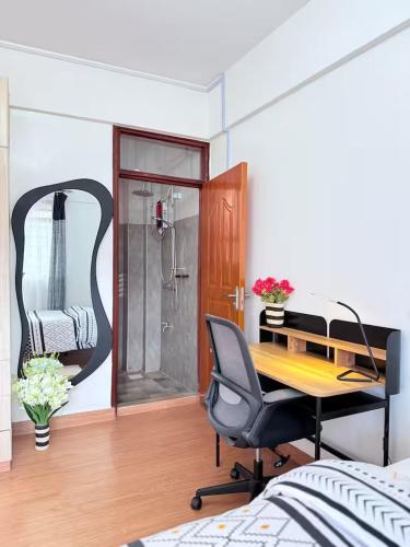 a bedroom with a desk and a shower and a chair at West residence in Ruaka