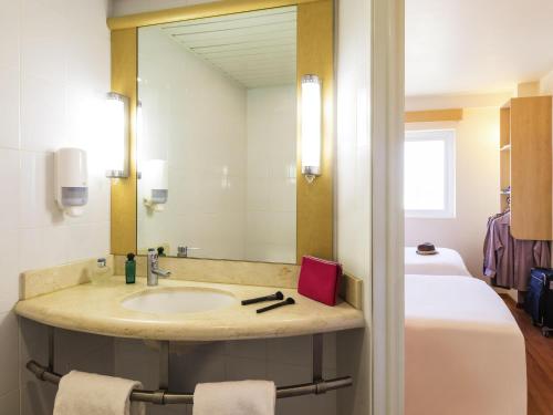 a bathroom with a sink and a mirror at Ibis Juarez Consulado in Ciudad Juárez
