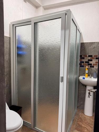 a bathroom with a shower and a toilet and a sink at Apartamento REFUGIO DEL LAGO in San Pedro La Laguna