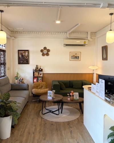 a living room with a couch and a table at Bangkok Neighborhouse - Guesthouse in Bangkok