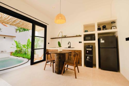 a kitchen and dining room with a table and a tub at Rumah Mana Villa in Tabanan