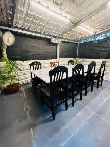 a table with four chairs and a table and a table and chairs at Twin Retreat in Madikeri