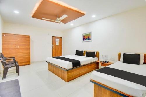 a bedroom with two beds and a ceiling fan at Hotel O Grand Executive in Chikalthān