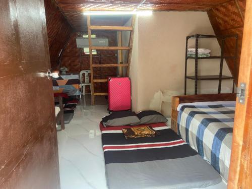 a room with two beds and a table with a pink suitcase at Sea Breeze Lodge in Siquijor