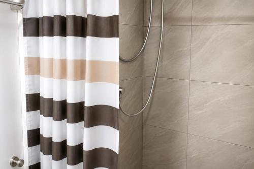 a shower with a black and white shower curtain at LJ CCC CozyNest at 32 Cebu Fast Wifi Netflix You tube in Cebu City