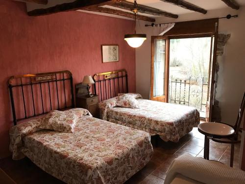 a bedroom with two beds in a room with a window at Casa Hipolito in Corduente