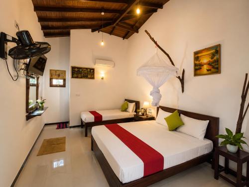 a bedroom with two beds in a room at Rainbow Safari & Lodge in Udawalawe