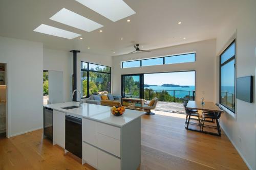 a kitchen and living room with a view of the ocean at Kokomea in Kaiteriteri