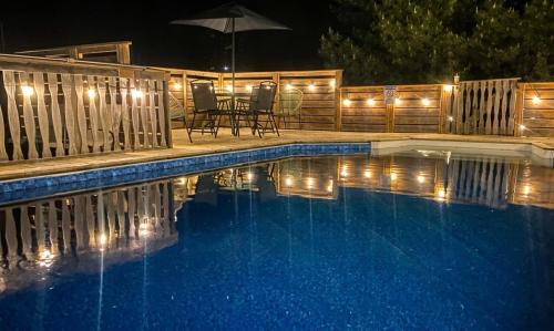 a swimming pool at night with a table and an umbrella at South Shore Suites in Bayfield