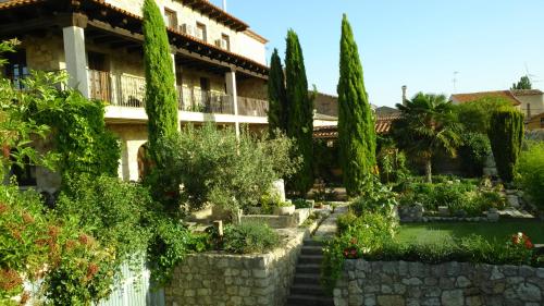 a garden in front of a building with trees at Hotel Rural San Pelayo in San Pelayo