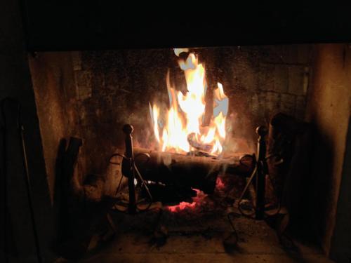 a fire in a brick fireplace with flames at Il Peschio in Pescocostanzo