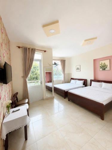 a hotel room with two beds and a tv at The Red Hotel Côn Đảo in Con Dao