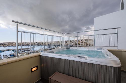 a hot tub on the balcony of a building at Seagull Penthouse Marsaxlokk in Marsaxlokk